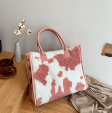 Statement Pink & White cow print faux fur tote bag on wooden surface with flowers